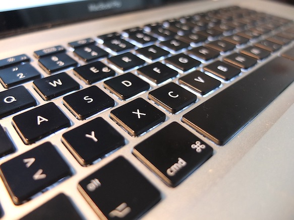 Close-up of a MacBook Pro keyboard with black keys and silver aluminum casing